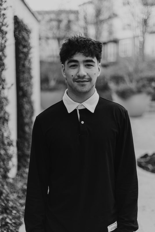 Black and white portrait by an ivy wall