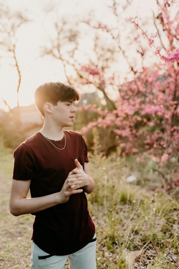 Senior beside a blooming spring tree