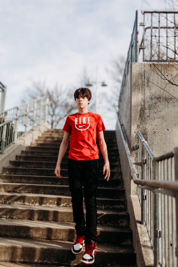 Senior on concrete steps in a red tee