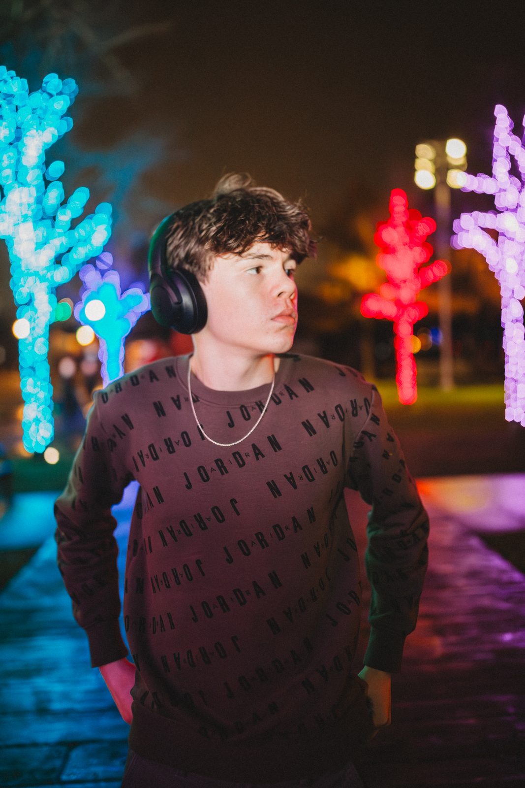 Senior in headphones under neon lights