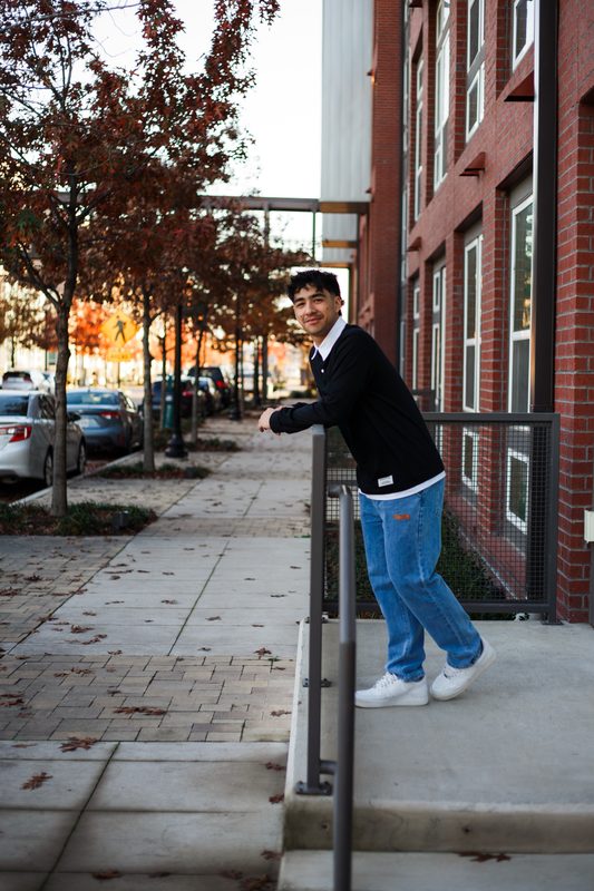 Senior leaning on a sidewalk rail