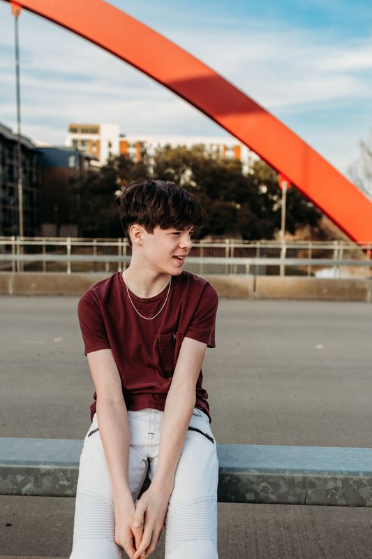 Senior seated on a rail below the arch
