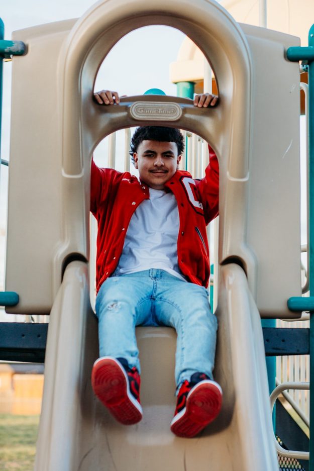 Senior sitting at the top of a slide