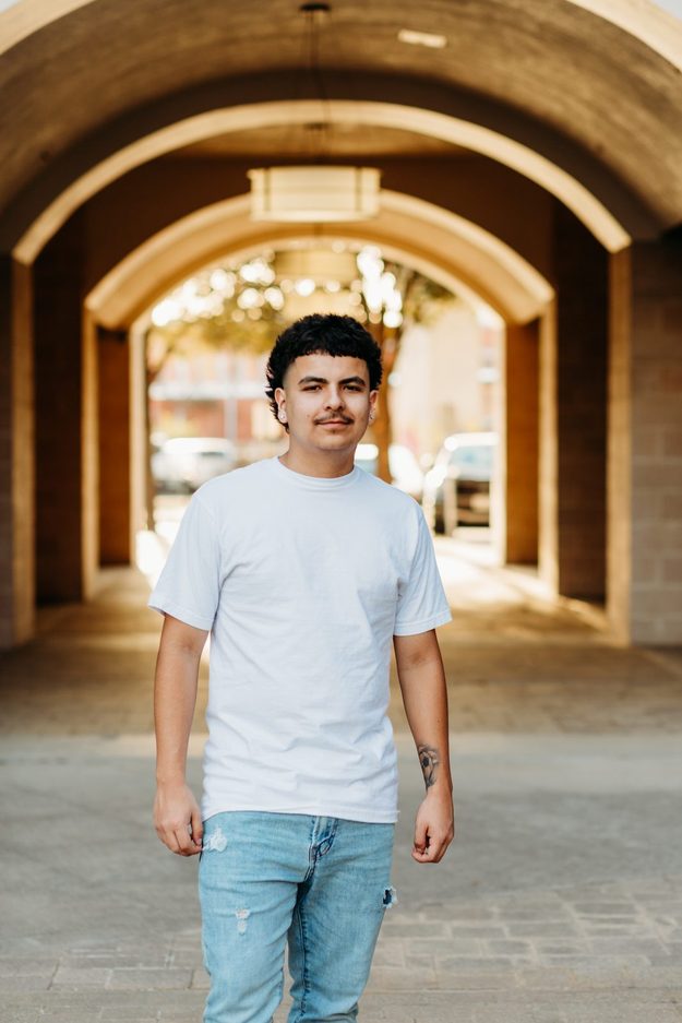 Senior standing in a downtown brick arch