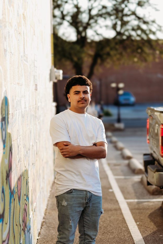 Senior with arms crossed in an alley