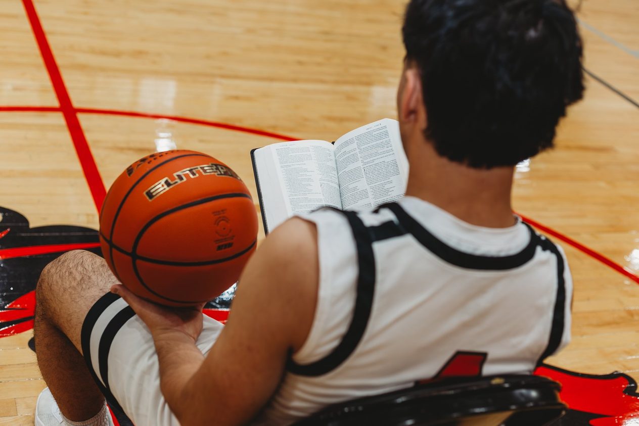 Senior with a book and a ball